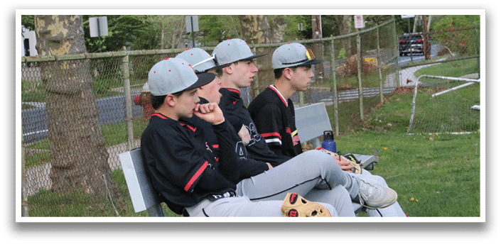 A group of baseball players sitting on a bench. Description generated by AI