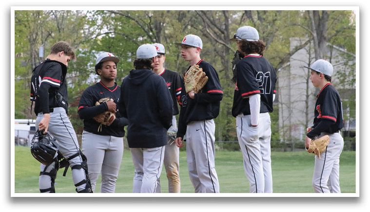 A group of baseball players standing on a field. Description generated by AI