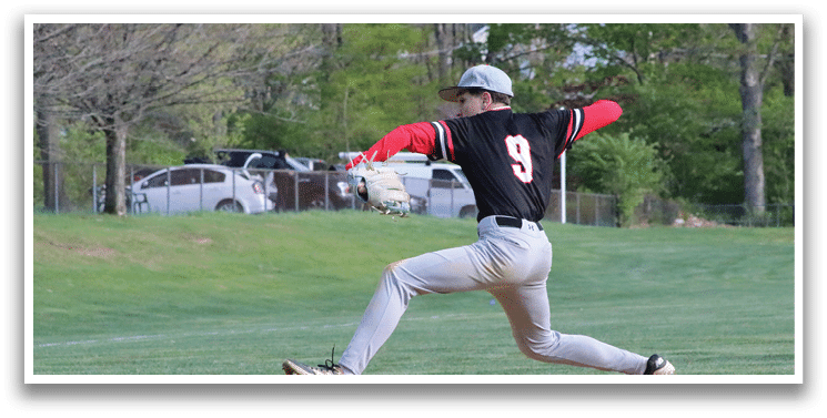 A baseball player in a black shirt and red hat is throwing a baseball. Description generated by AI