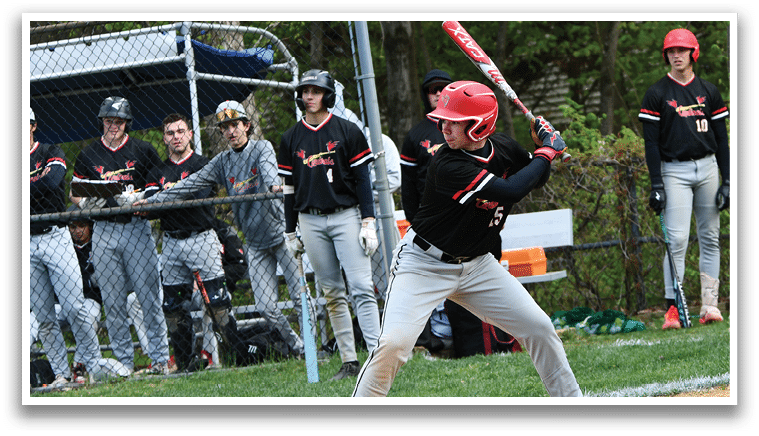 A baseball player in a black and red uniform is swinging a bat. Description generated by AI
