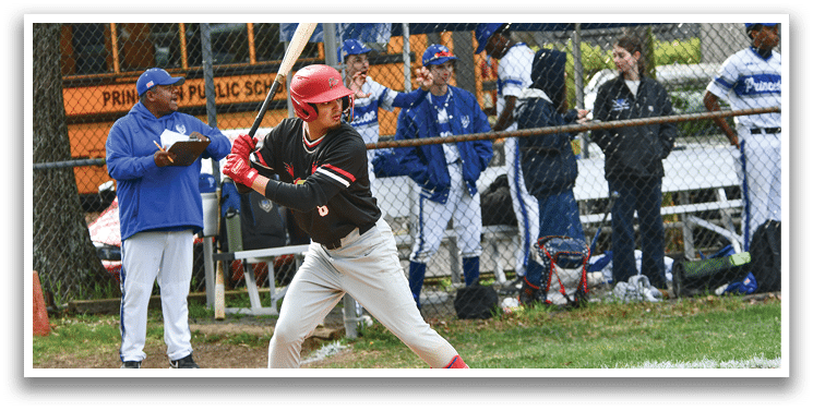 A baseball player in a red helmet and black shirt is swinging a bat. Description generated by AI