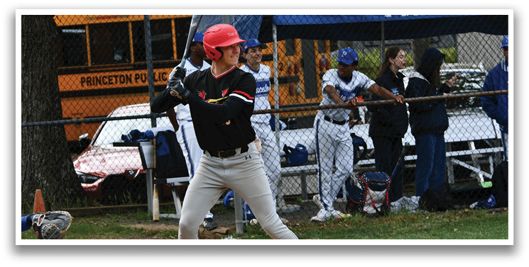 A baseball player in a black shirt and red helmet is swinging a bat. Description generated by AI