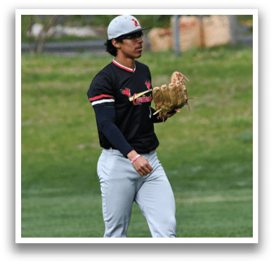 A baseball player wearing a black and red shirt and grey pants. Description generated by AI
