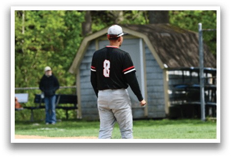 A man wearing a black and red shirt with the number 8 on it. Description generated by AI