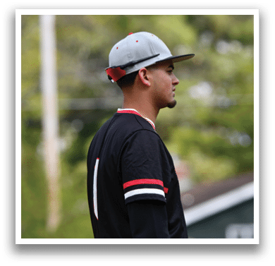 A man wearing a black and red baseball jersey. Description generated by AI