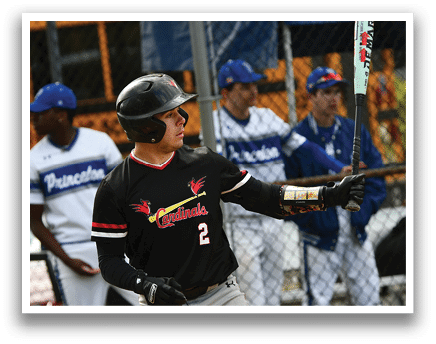A baseball player in a black shirt and red and white uniform is holding a bat. Description generated by AI