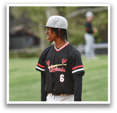 A man wearing a baseball cap and a black and red jersey. Description generated by AI