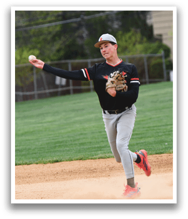 A baseball player wearing a black and red shirt and grey pants is throwing a ball. Description generated by AI