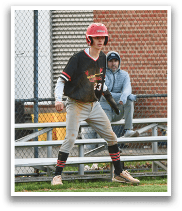 A boy wearing a baseball uniform walks on a field. Description generated by AI