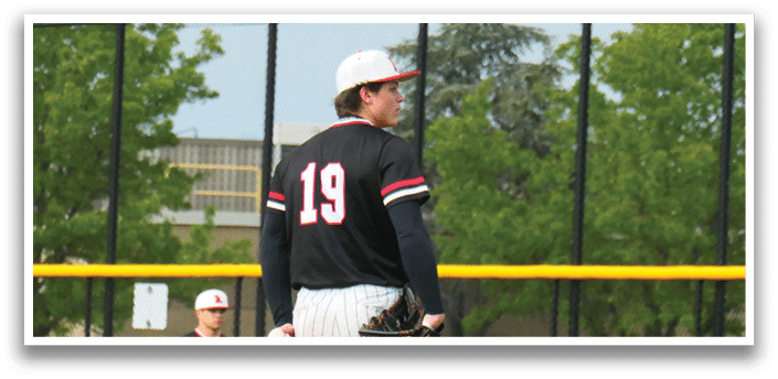 A pitcher on a baseball field wearing a black and red jersey. Description generated by AI
