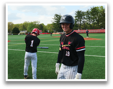 A baseball player wearing a black and red jersey. Description generated by AI