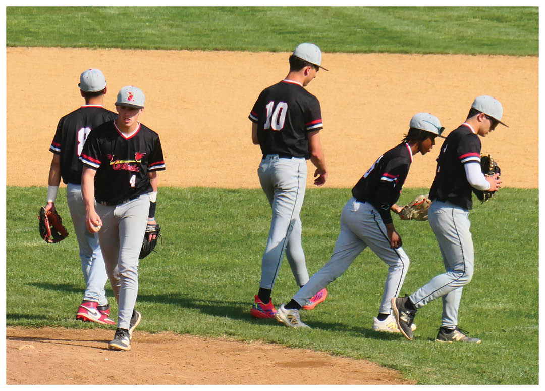 Three baseball players walking on a field. Description generated by AI