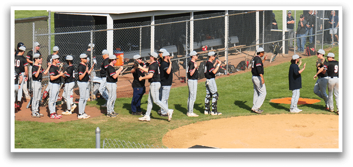 A group of baseball players are standing on a field. Description generated by AI