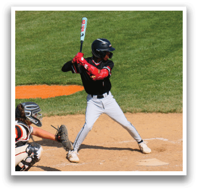 A baseball player is swinging a bat on a field. Description generated by AI