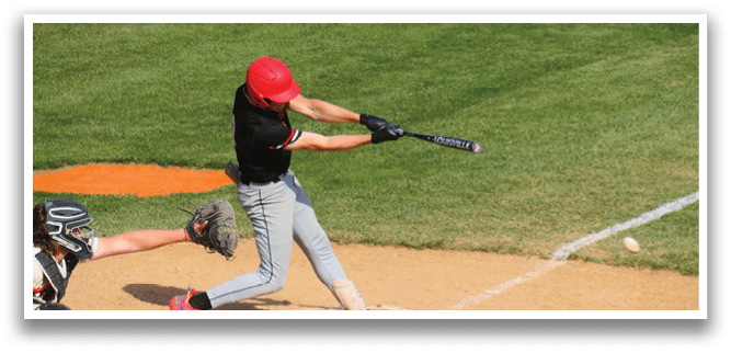A baseball player in a black and red shirt is swinging a bat at a ball. Description generated by AI
