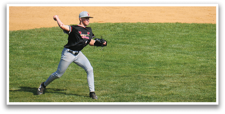 A baseball player in a black shirt and grey pants is throwing a ball. Description generated by AI