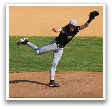 A baseball player in a black shirt and grey pants is pitching a ball. Description generated by AI