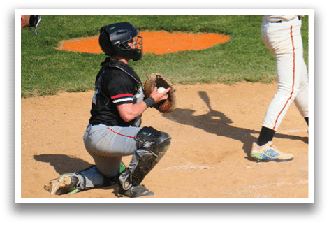 A baseball player is crouched down in the dirt. Description generated by AI