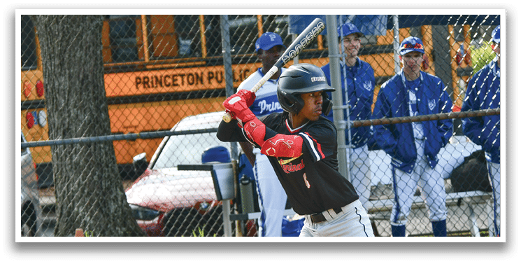 A baseball player in a black shirt and red gloves is swinging a bat. Description generated by AI