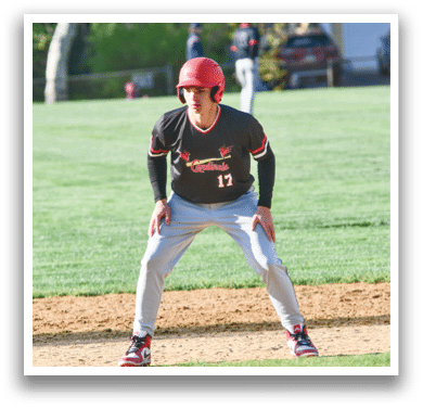 A baseball player wearing a red helmet and a black shirt with the number 12 on it. Description generated by AI