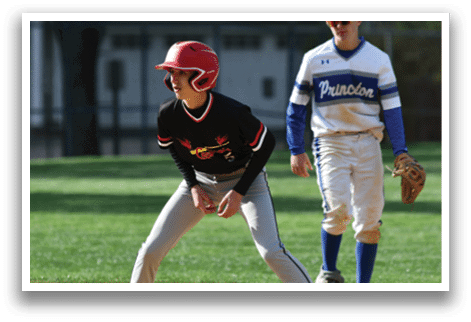 A boy in a red helmet and black shirt is playing baseball. Description generated by AI