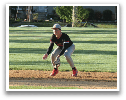 A baseball player is crouching on the field. Description generated by AI