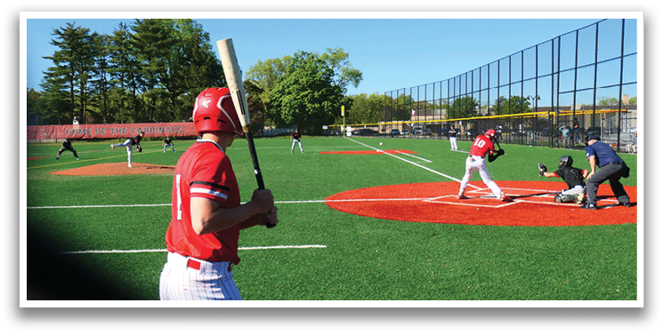 A baseball player in a red shirt and white pants holding a bat. Description generated by AI