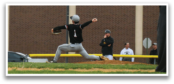 A baseball player in a black shirt and white pants is pitching a ball. Description generated by AI