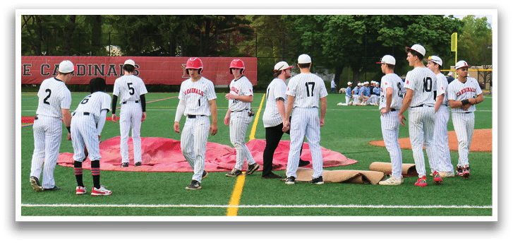 A group of baseball players standing on a field. Description generated by AI