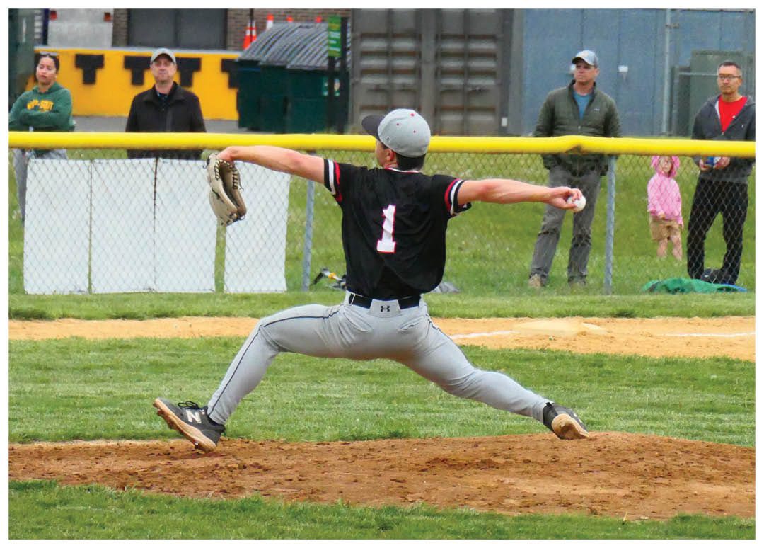 A baseball player in a black shirt and grey pants is throwing a ball. Description generated by AI