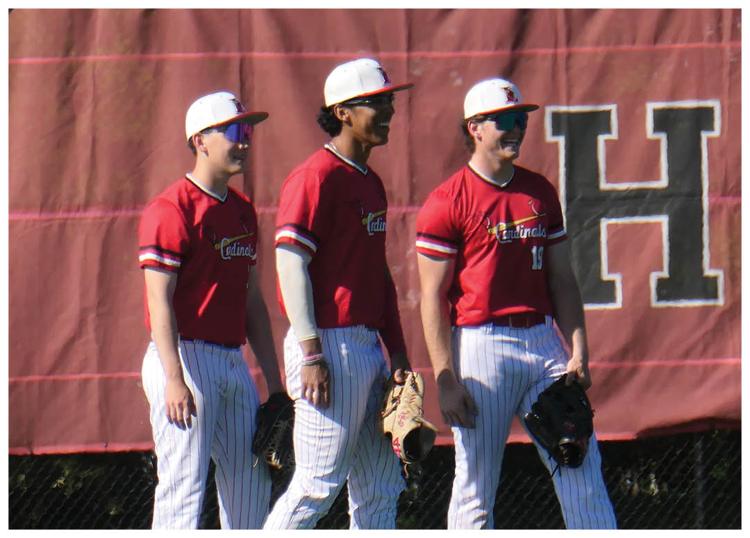 Three baseball players wearing red and white uniforms. Description generated by AI