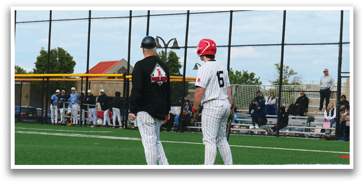 Two men wearing baseball uniforms standing on a field. Description generated by AI