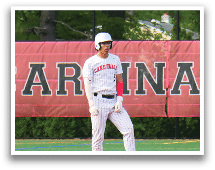 A baseball player wearing a white uniform stands on a field. Description generated by AI