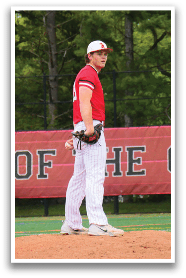 A baseball player standing on a pitcher's mound. Description generated by AI
