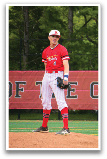 A baseball player wearing a red shirt and red socks. Description generated by AI
