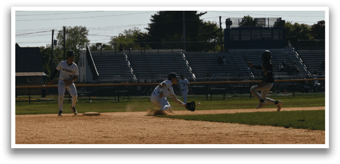 A baseball game is taking place on a field with a player sliding into home base. Description generated by AI