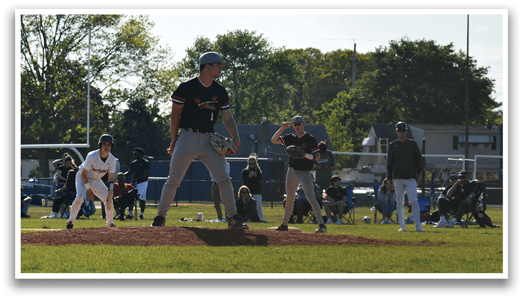 A baseball player in a black shirt and grey pants is pitching a ball. Description generated by AI