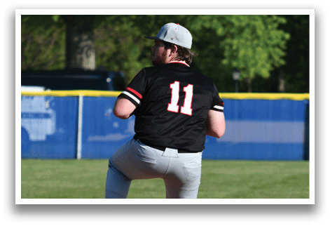 A baseball player in a black shirt and white pants is pitching a ball. Description generated by AI
