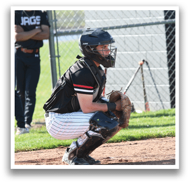 A baseball player wearing a black and red jersey. Description generated by AI