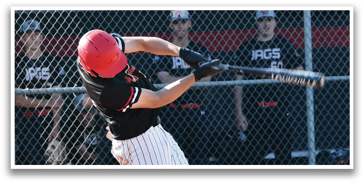 A baseball player in a black and red shirt is swinging a bat. Description generated by AI