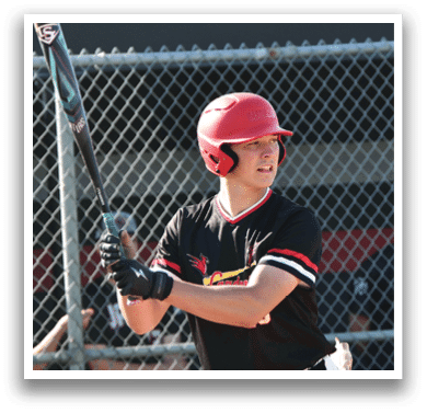 A baseball player in a black and red shirt holding a bat. Description generated by AI