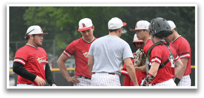 A group of baseball players wearing red and white uniforms. Description generated by AI