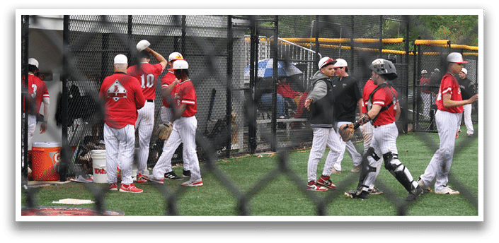 A group of baseball players standing on a field. Description generated by AI