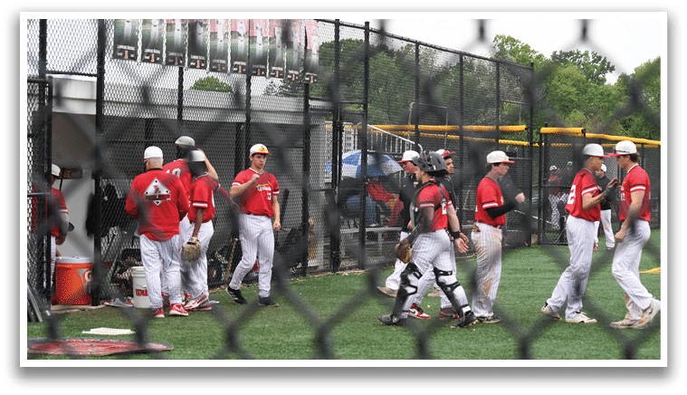 A group of baseball players standing on a field. Description generated by AI