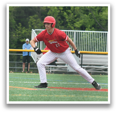 A baseball player in a red shirt and white pants is standing on the field. Description generated by AI