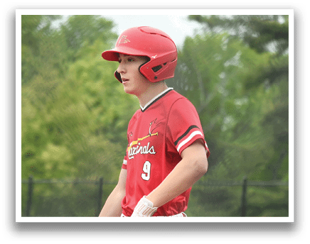 A boy wearing a red baseball uniform with the number 9 on the back. Description generated by AI