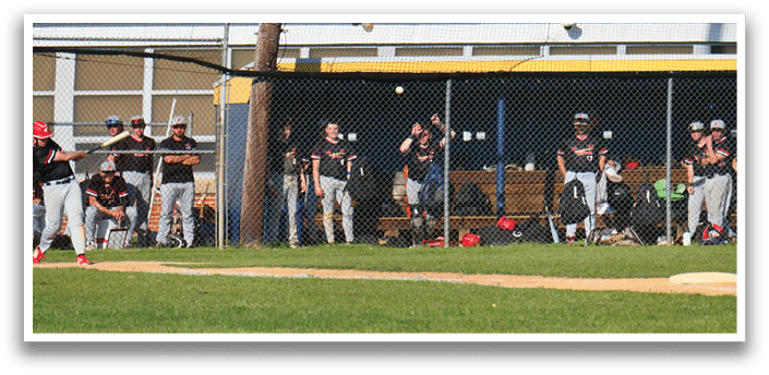 A baseball field with a group of people standing around. Description generated by AI