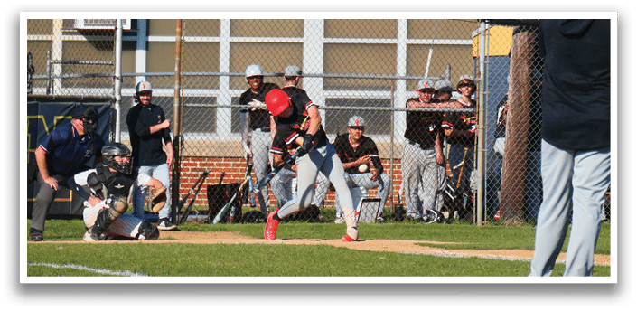 A baseball player is holding a bat, ready to hit the ball. Description generated by AI