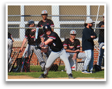 A baseball game is taking place with a man in a black shirt and a black hat standing on the field. Description generated by AI