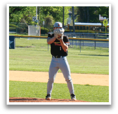 A baseball player in a black shirt and white number 20 on the back of his jersey. Description generated by AI